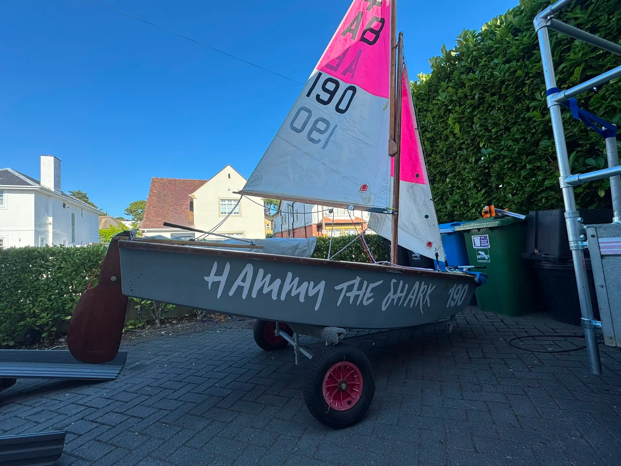 Hammy the Shark side on, on her trolley with red wheels, the pink and white sails hoisted.